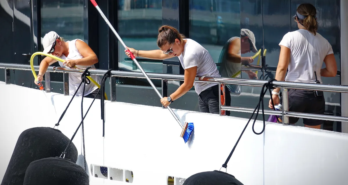 Crew washing down a yacht’s deck