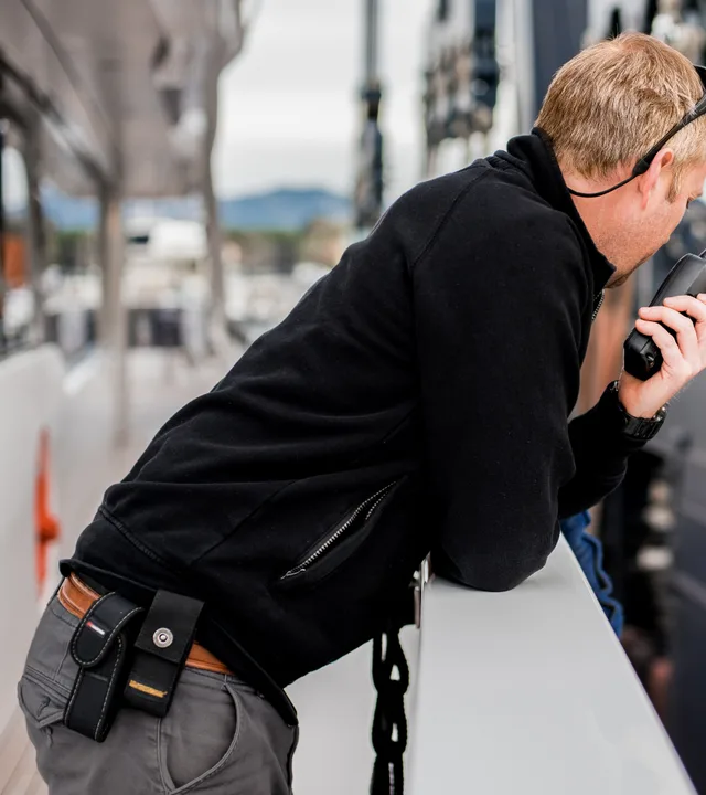 Deck crew coordinating with a handheld radio