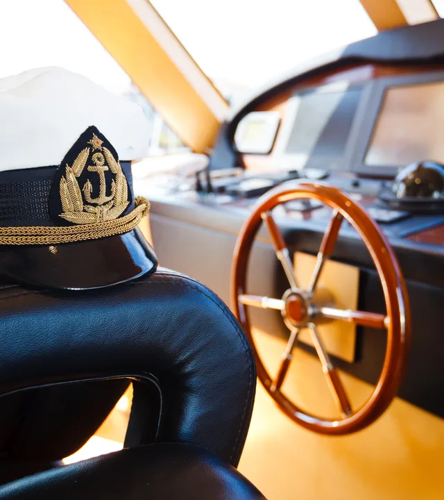 A captain’s cap resting on the helm chair
